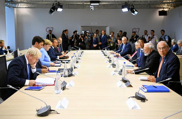 Britain's Prime Minister Boris Johnson, Canadian Prime Minister Justin Trudeau, German Chancellor Angela Merkel, French President Emmanuel Macron, South African President Cyril Ramaphosa, European Council President Donald Tusk, Italian Prime Minister Giuseppe Conte, Japanese Prime Minister Shinzo Abe and Indian Prime Minister Narendra Modi attend a working lunch with world leaders during the G7 summit in Biarritz, France, August 26, 2019. REUTERS/Dylan Martinez/Pool