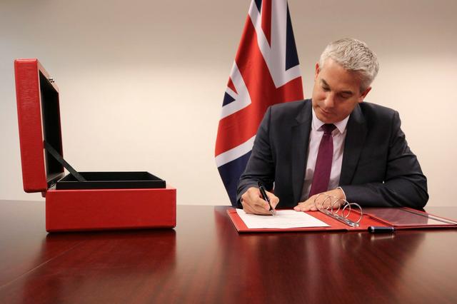 FILE PHOTO: Brexit Secretary Stephen Barclay signs the commencement agreement to leave the EU, in undisclosed location August 16, 2019,  in this picture obtained from social media. STEVE BARCLAY/via REUTERS