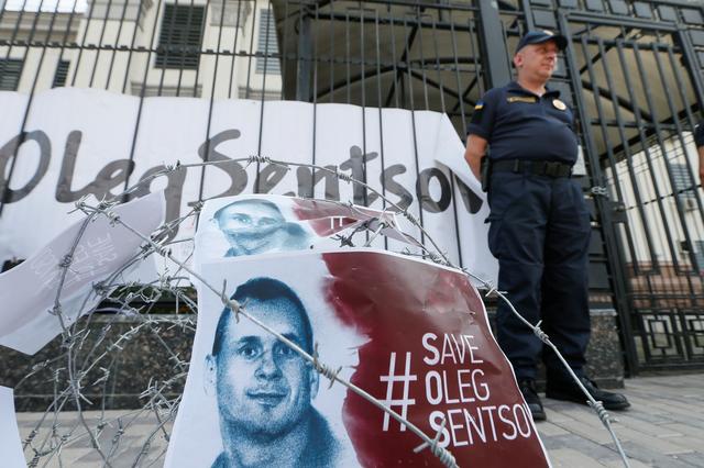 FILE PHOTO - Barbed wire and placards with images of Ukrainian film director Oleg Sentsov are seen after a rally demanding the release of Sentsov, who was jailed on terrorism charges and is currently on hunger strike in Russian jail, in front of the Russian embassy in Kiev, Ukraine August 21, 2018. REUTERS/Valentyn Ogirenko