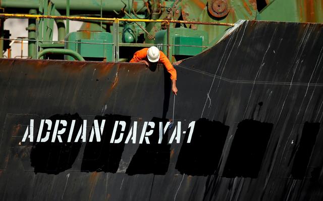 FILE PHOTO: A crew member takes pictures with a mobile phone on Iranian oil tanker Adrian Darya 1, previously named Grace 1, as it sits anchored after the Supreme Court of the British territory lifted its detention order, in the Strait of Gibraltar, Spain, August 18, 2019. REUTERS/Jon Nazca/File Photo