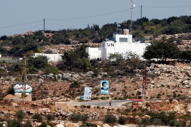FILE PHOTO: A banner depicting Hezbollah leader Sayyed Hassan Nasrallah and an United Nation's post are seen in Lebanon from the Israeli side of the border, near Zar'it in northern Israel August 28, 2019. REUTERS/Ammar Awad/File Photo