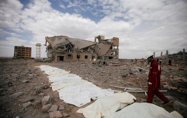 A Red Crescent medic walks next to bags containing the bodies of victims of Saudi-led airstrikes on a Houthi detention centre in Dhamar, Yemen, September 1, 2019.  REUTERS/Mohamed al-Sayaghi