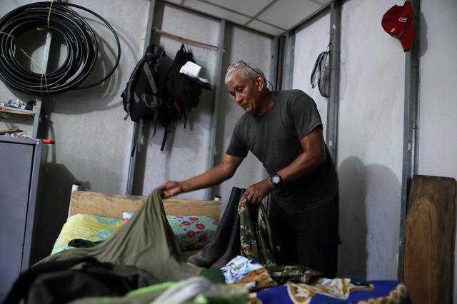 Ricardo Bolanos, former rebel of the Revolutionary Armed Forces of Colombia (FARC), shows the clothes he wore when he was in combat, at a reintegration camp in Pondores, Colombia August 2, 2019. REUTERS/Luisa Gonzalez