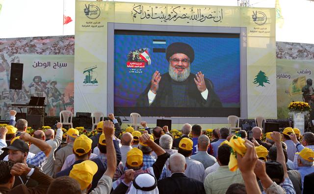FILE PHOTO: Lebanon's Hezbollah leader Sayyed Hassan Nasrallah gestures as he addresses his supporters via a screen during a rally marking the anniversary of the defeat of militants near the Lebanese-Syrian border, in al-Ain village, Lebanon August 25, 2019. REUTERS/Aziz Taher