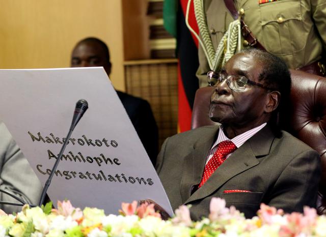 FILE PHOTO:  Zimbabwe's President Robert Mugabe reads a card during his 93rd birthday celebrations in Harare, Zimbabwe, February 21, 2017. REUTERS/Philimon Bulawayo/File Photo