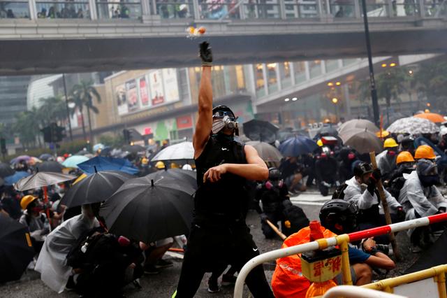 An anti-extradition bill protester throws eggs as protesters clash with riot police during a rally to demand democracy and political reforms, at Tsuen Wan, in Hong Kong, China August 25, 2019. REUTERS/Tyrone Siu    