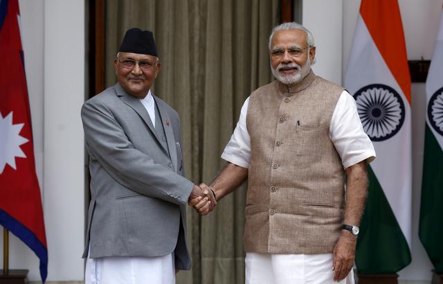 FILE PHOTO: Nepal's Prime Minister Khadga Prasad Sharma Oli (L) shakes hands with his Indian counterpart Narendra Modi during a photo opportunity ahead of their meeting at Hyderabad House in New Delhi, India, February 20, 2016. REUTERS/Adnan Abidi