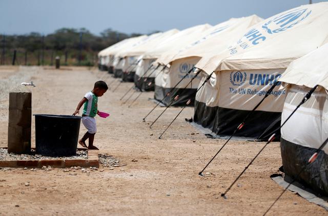 FILE PHOTO: A Venezuelan migrant child walks next to a water tank, in a camp run by the UN refugee agency UNHCR in Maicao, Colombia May 6, 2019. REUTERS/Luisa Gonzalez/File Photo
