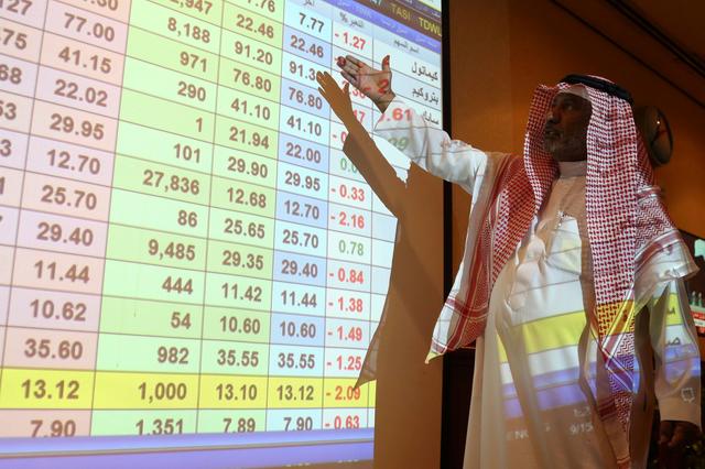 A saudi man inspect a screen showing stock prices at ANB Bank, in Riyadh Saudi Arabia September 15, 2019. REUTERS/Stringer