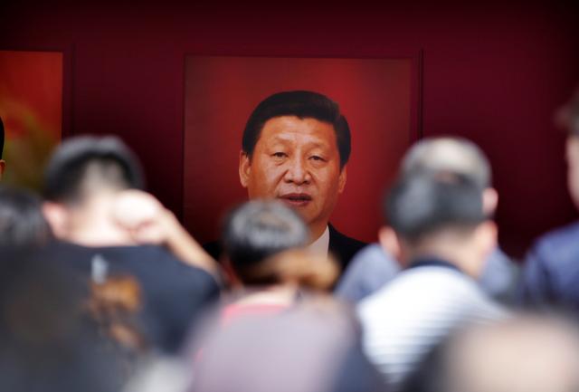 FILE PHOTO: Visitors are seen in front of a picture of Chinese President Xi Jinping during an exhibition on China's achievements marking the 70th anniversary of the founding of the People's Republic of China (PRC) at the Beijing Exhibition Center, in Beijing, China September 24, 2019. REUTERS/Jason Lee/File Photo