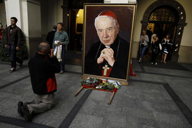 FILE PHOTO: A Catholic prays in front of the picture of former Polish Cardinal Stefan Wyszynski a day prior to celebrations of the Assumption of Mary at Jasna Gora Monastery in Czestochowa August 14, 2012. REUTERS/Kacper Pempel