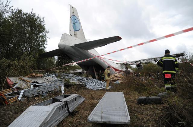 Members of emergency services work at the site of the Antonov-12 cargo airplane emergency landing in Lviv region, Ukraine October 4, 2019. REUTERS/Mykola Tys