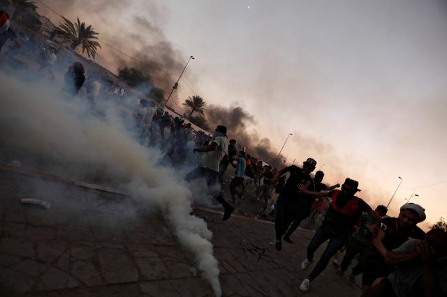 FILE PHOTO: Demonstrators disperse as Iraqi security forces use tear gas during a protest after the lifting of the curfew, following four days of nationwide anti-government protests that turned violent, in Baghdad, Iraq October 5, 2019. REUTERS/Thaier Al-Sudani