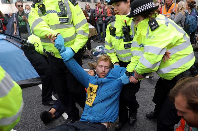 Police officers detain an Extinction Rebellion protester during a demonstration outside the Home Office in London, Britain, October 8, 2019. REUTERS/Simon Dawson