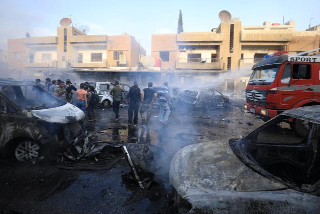 People gather at the site of a car bomb blast in Qamishli, Syria October 11, 2019. REUTERS/Rodi Said