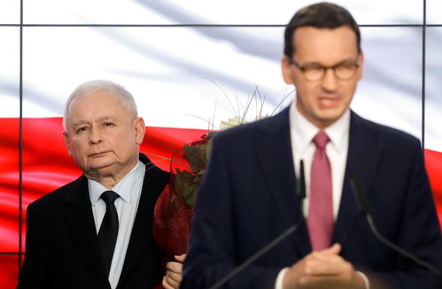 Poland's ruling party Law and Justice (PiS) leader Jaroslaw Kaczynski looks on as Polish Prime Minister Mateusz Marowiecki speaks after the exit poll results are announced in Warsaw, Poland, October 13, 2019. REUTERS/Kacper Pempel