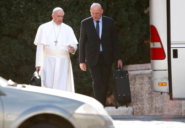 FILE PHOTO: Pope Francis is seen at the Vatican walking next to Domenico Giani, Inspector General of the Corpo della Gendarmeria, the police and security force of Vatican City, before boarding a bus heading to Ariccia, south of Rome, to make his Lent spiritual exercises March 5, 2017. REUTERS/Tony Gentile