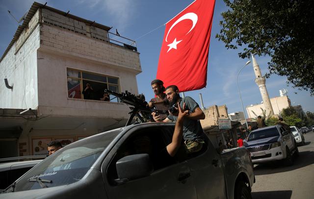 Turkish-backed Syrian rebels drive on a street in the Turkish border town of Akcakale in Sanliurfa province, Turkey, October 14, 2019. REUTERS/Stoyan Nenov