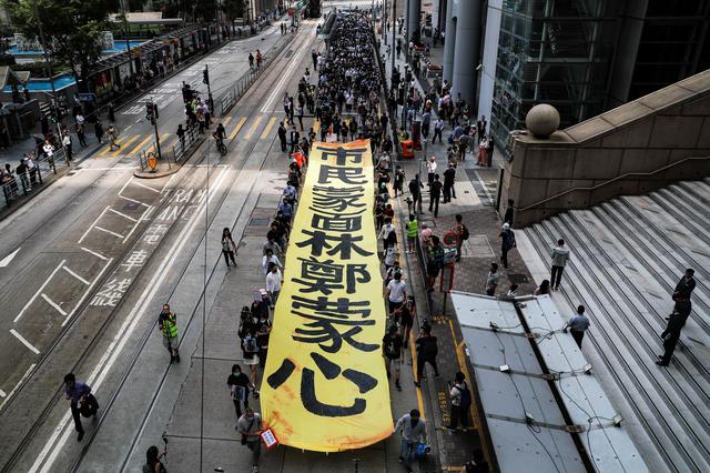 People march with a banner to protest against what they say is the abuse of pro-democracy protesters by Hong Kong police, near Chater Garden in Central district, Hong Kong, China October 18, 2019. REUTERS/Ammar Awad