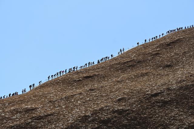 Tourists climb Uluru, formerly known as Ayers Rock, at Uluru-Kata Tjuta National Park in the Northern Territory, Australia, October 25, 2019. Friday is the last day people will be able to climb Uluru. AAP Image/Lukas Coch/via REUTERS    