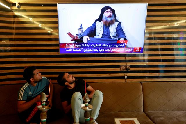 FILE PHOTO: Iraqi youth watch the news of Islamic State leader Abu Bakr al-Baghdadi death, in Najaf, Iraq October 27, 2019. REUTERS/Alaa al-Marjani/File Photo