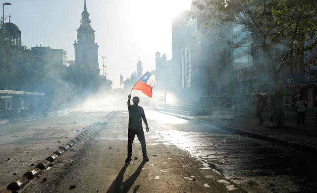 A demonstrator waves a Chilean flag during a protest against Chile's government in Santiago, Chile October 29, 2019. REUTERS/Jorge Silva