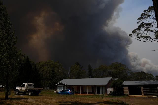 FILE PHOTO: A home is seen as smoke from the Grose Valley Fire rises in the distance, at Bilpin, New South Wales, Australia, December 21, 2019. AAP Image/Dan Himbrechts via REUTERS/File Photo