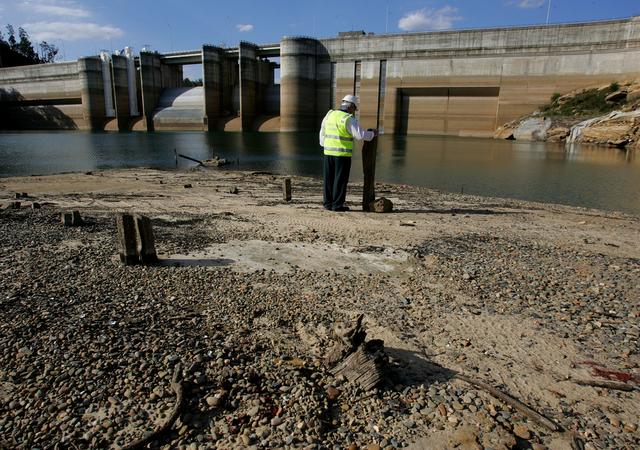 FILE PHOTO: Dick Pearson from the Sydney Catchment Authority stands in front of Sydney's Warragamba Dam to show the lowest level the dam has ever been.  REUTERS/David Gray