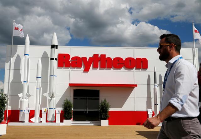FILE PHOTO: A visitor walks past the Raytheon stand at the 53rd International Paris Air Show at Le Bourget Airport near Paris, France June 21, 2019. REUTERS/Pascal Rossignol