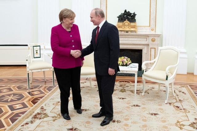 Russian President Vladimir Putin and German Chancellor Angela Merkel shake hands prior to the talks in the Kremlin in Moscow, Russia, January 11, 2020. Pavel Golovkin/Pool via REUTERS