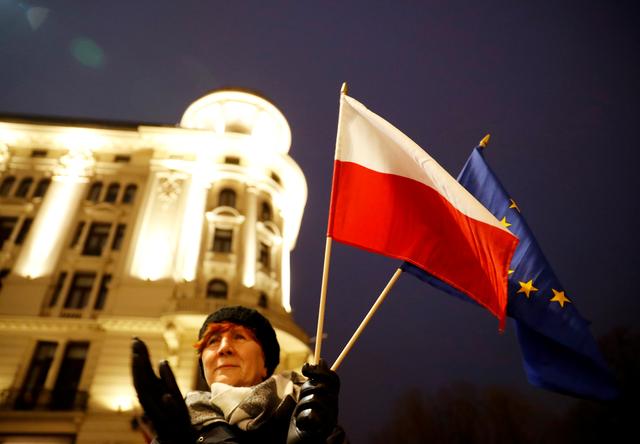 A woman holds Polish an EU flags as she attends a protest against judiciary reform in Warsaw, Poland January 11, 2020. REUTERS/Kacper Pempel