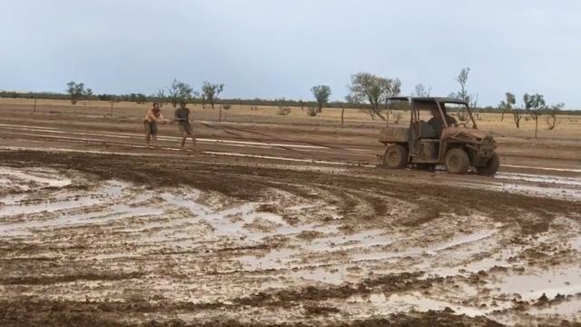 FILE PHOTO: A buggy pulls people, sliding around in the mud, as they celebrate the rainfall in Winton, Queensland, Australia January 15, 2020 in this still image taken from social media video. Teonie Dwyer via REUTERS