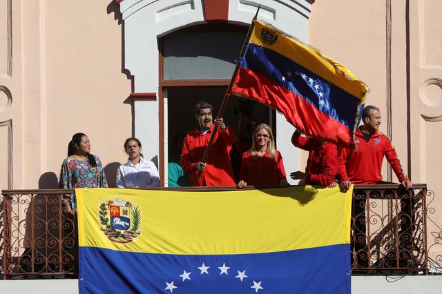 Venezuela's President Nicolas Maduro, accompanied by his wife Cilia Flores, holds a Venezuelan flag from the balcony of the Miraflores Palace in Caracas, Venezuela January 23, 2020. REUTERS/Fausto Torrealba NO RESALES, NO ARCHIVES