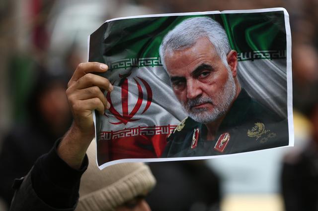 FILE PHOTO: An Iranian holds a picture of late General Qassem Soleimani, head of the elite Quds Force, who was killed in an air strike at Baghdad airport, as people gather to mourn him in Tehran, Iran January 4, 2020. Nazanin Tabatabaee/WANA (West Asia News Agency) via REUTERS 