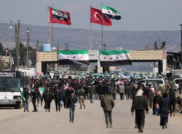 FILE PHOTO: Internally displaced Syrians hold Syrian opposition flags during a protest in support of the Turkish army and Turkey backed Syrian rebels at the Bab el-Salam border crossing between the Syrian town of Azaz and the Turkish town of Kilis, in Syria, February 25, 2020. REUTERS/Khalil Ashawi/File Photo