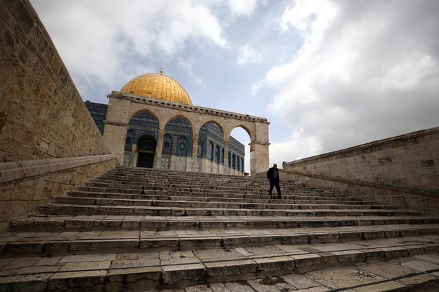 A man walks in front of the Dome of the Rock in the compound known to Muslims as Noble Sanctuary and to Jews as Temple Mount in Jerusalem's Old City, after Muslim clerics shut the doors of Al-Aqsa mosque and the Dome of the Rock until further notice as a precaution against coronavirus March 15, 2020. REUTERS/Ammar Awad