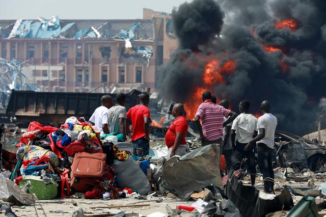 People gather with their belongings at the scene of the fire outbreak at Abule-Ado in Lagos, Nigeria March 15, 2020. REUTERS/Temilade Adelaja