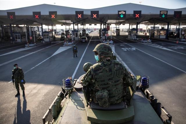 A Serbian army soldier sits on top of armoured personal carrier at the Serbia's Batrovci border crossing with Croatia's Bajakovo, as the number of coronavirus (COVID-19) cases grow around the world near Batrovci, Serbia, March 18, 2020. REUTERS/Marko Djurica