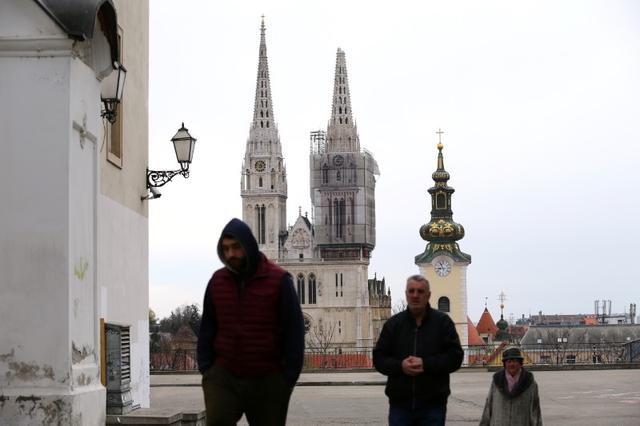 People walk as the cathedral of Zagreb is seen damaged following an earthquake, in Zagreb, Croatia March 22, 2020. REUTERS/Antonio Bronic