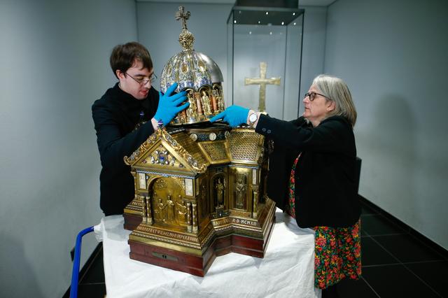 Restorer Luke Jonathan Koeppe and the director of the cathedral treasury Birgitta Falk present shrine with the relics of Saint Corona, the patron of epidemics, at the cathedral in Aachen, Germany, March 25, 2020 as the spread of the coronavirus disease (COVID-19) continues. REUTERS/Thilo Schmuelgen