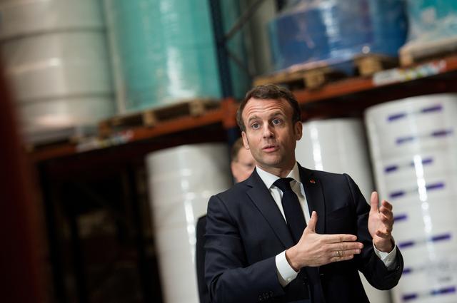 French President Emmanuel Macron talks to employees as he visits the Kolmi-Hopen protective face masks factory, following an outbreak of the coronavirus disease (COVID-19), in Saint-Barthelemy-d'Anjou near Angers, France March 31, 2020. Loic Venance/Pool via REUTERS