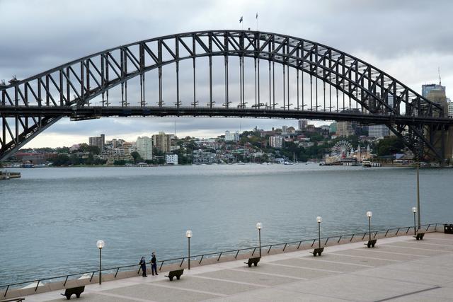 FILE PHOTO: Police officers patrol near the Sydney Harbour Bridge following the implementation of stricter social-distancing and self-isolation rules to limit the spread of the coronavirus disease (COVID-19) in Sydney, Australia, April 6, 2020. REUTERS/Loren Elliott