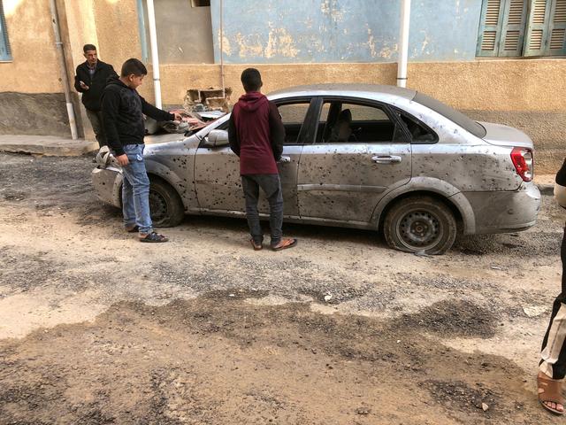 FILE PHOTO: Libyan boys check a damaged car after a shell fell on a residential area at Hadba al-Badri district, in Tripoli, Libya January 28, 2020. REUTERS/Ismail Zitouny/File Photo