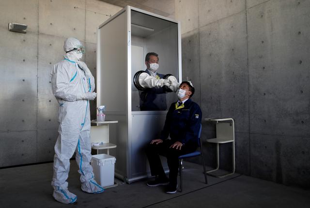 A medical worker conducts a simulation for a walk-in style polymerase chain reaction (PCR) test for the coronavirus disease (COVID-19), at a makeshift facility in Yokosuka, south of Tokyo, Japan, April 23, 2020. REUTERS/Issei Kato