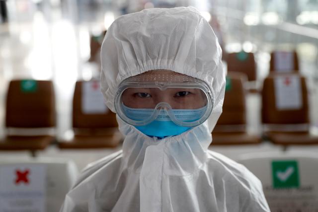 FILE PHOTO: A chinese student living in Thailand wears a protective suit as a measure of protection against the coronavirus disease (COVID-19) at the Suvarnabhumi Airport before boarding a repatriation flight, in Bangkok, Thailand, April 21, 2020. REUTERS/Jorge Silva