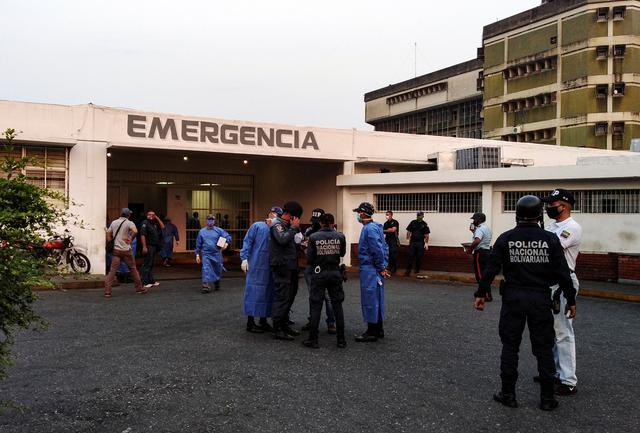 Healthcare workers and members of the Bolivarian national police wait for the arrival of prisoners outside a hospital after a riot erupted inside a prison in Guanare, Venezuela May 1, 2020. REUTERS/Manuel Alvarado 