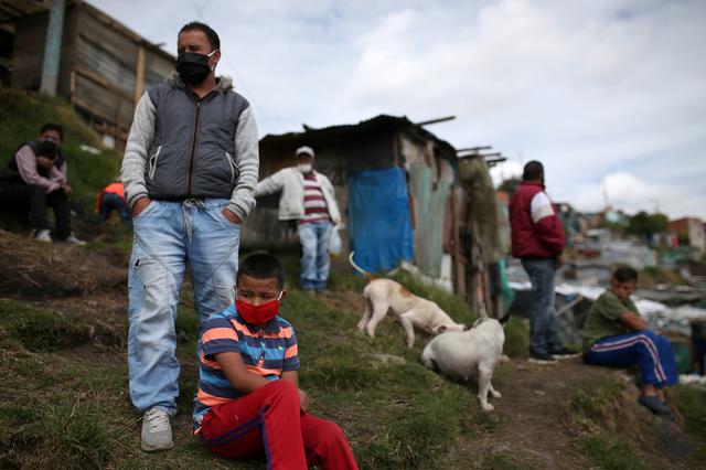 People, wearing masks, are seen on a field that, according to the mayor's office, is at high risk of collapse and its inhabitants will be evicted, amid the coronavirus disease (COVID-19) outbreak in Bogota, Colombia May 15, 2020. REUTERS/Luisa Gonzalez