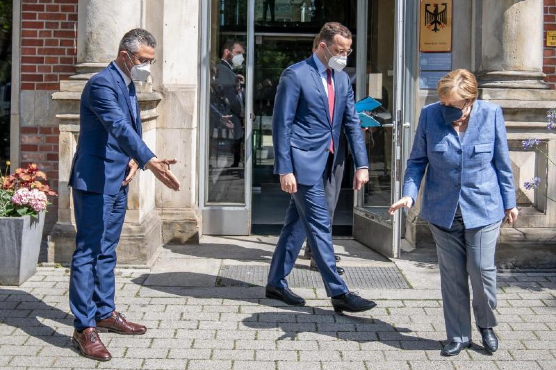 Angela-Merkel-sucht-neben-Jens-Spahn-und-Lothar-Wieler-die-Bodenmarkierung-fuer-das-Gruppenbild.jpg