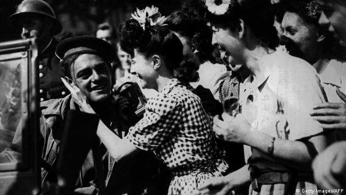 Young Parisian women greet Allied soldiers as they enter Paris during its liberation in late August 1944