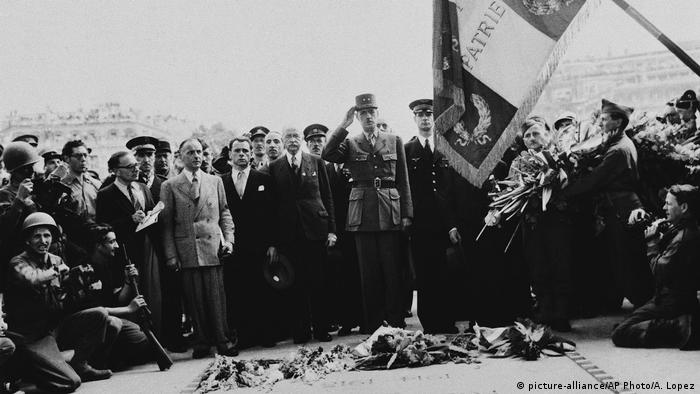 General Charles De Gaulle, center, salutes the Tricolor after placing his wreath on the Tomb of the French Unknown Soldier in Paris, France on August 28, 1944